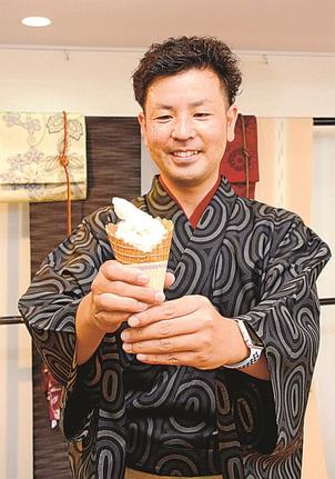シルクパウダー入りのソフトクリームを手にする影山晃司社長＝出雲市今市町、影山呉服店