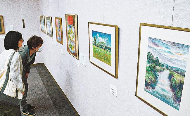多彩な技法で創作された作品に見入る来場者＝鳥取県日南町霞、同町美術館
