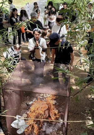 故人への思いをつづった手紙を火にくべ、祈りをささげる参加者＝松江市東出雲町揖屋、黄泉比良坂