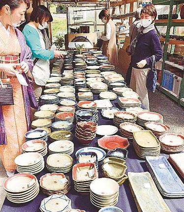 熱心に品定めする来場者＝大田市温泉津町温泉津、（有）椿窯