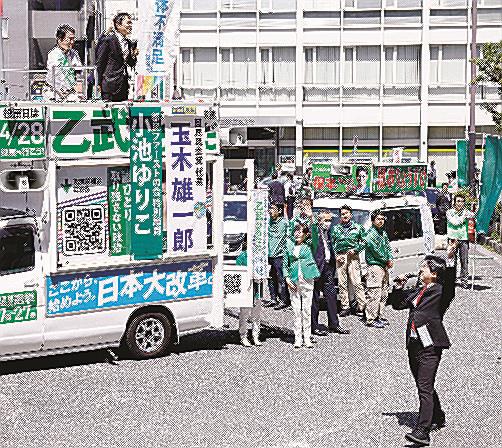 衆院東京１５区補欠選挙の告示日、立候補した乙武洋匡氏（左上）の演説会場周辺で声を上げる政治団体「つばさの党」の黒川敦彦代表（右下）＝４月１６日、東京都江東区