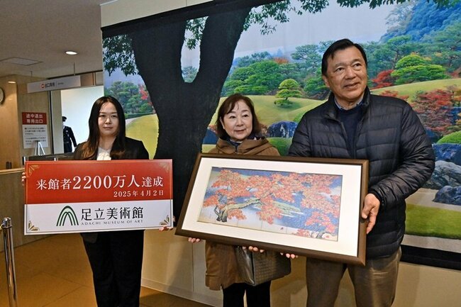 2200万人目の来場者となった坂本隆盛さん(右)=安来市古川町、足立美術館