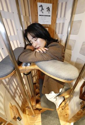 東京・原宿の「睡眠カフェ」に期間限定で設置された立ち寝体験席＝８月２２日
