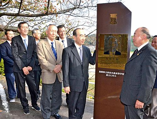 浜田水産高校に設置した丸川久俊の記念碑を囲む浜水会の関係者＝２０１９年１１月、浜田市瀬戸ケ島町