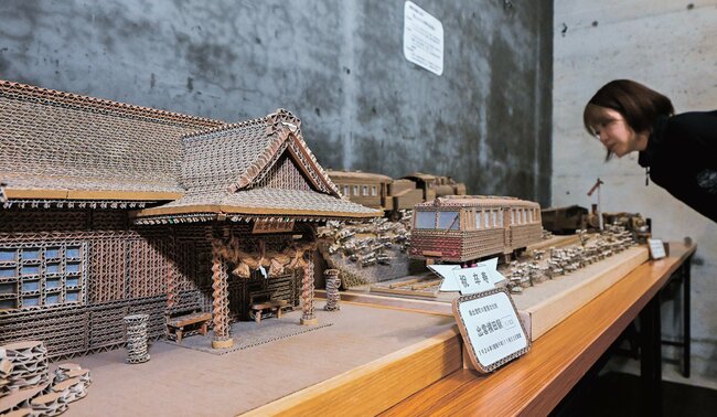 段ボールで制作した駅舎や列車の作品を見る関係者＝雲南市木次町寺領、ワイナリー奥出雲葡萄園