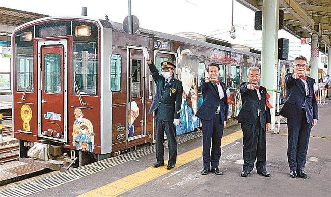 コナンの決めぜりふ時のポーズで新コナン列車を見送る関係者＝鳥取市東品治町、鳥取駅