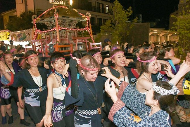声をそろえて女宮を担ぐ女性＝松江市天神町