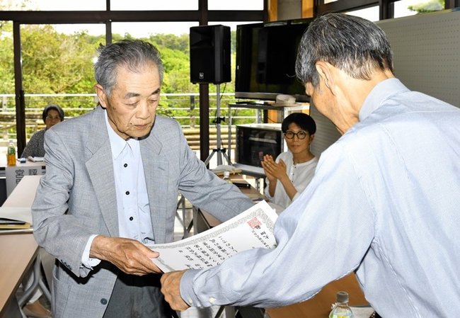 特選に選ばれて賞状を受け取る小田裕侯さん（左）＝益田市高津町、島根県立万葉公園管理センター