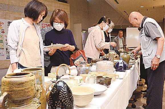 作品を手に取り、品定めする来場者＝松江市東津田町、いきいきプラザ島根