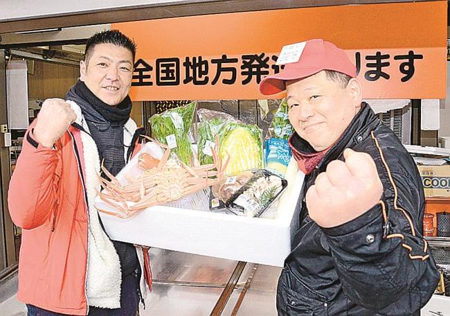 カニ鍋セットを手にする中脇喜一郎社長（左）と三浦淳社長＝松江市伊勢宮町、魚清