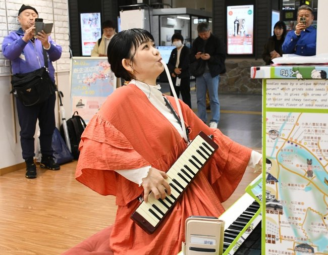 ピアノと鍵盤ハーモニカを演奏するみのりさん＝松江市朝日町、ＪＲ松江駅構内