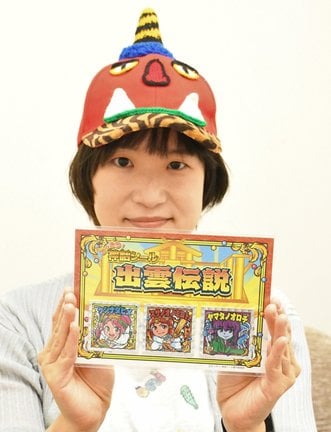 「どっきり！神話シール　出雲伝説」を手にするさくらいみかさん＝松江市内