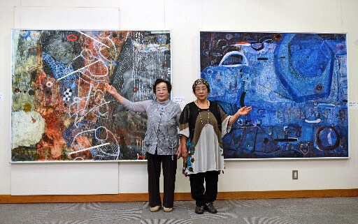 自作の前に立つ田辺二枝さん（左）と山〓（崎の大が立の下の横棒なし)一枝さん＝安来市安来町、観光交流プラザ