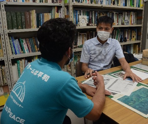 ラミンさん（手前）が日本で長く暮らせる方策を一緒に考える増永二之教授＝松江市西川津町、島根大松江キャンパス