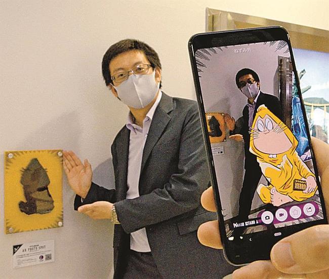 専用アプリをアクリル板にかざすとキャラクターが画面上に映し出される＝境港市佐斐神町、米子空港