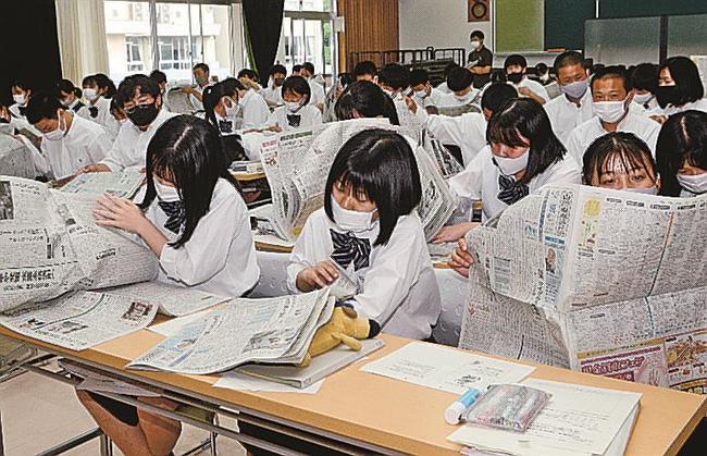 本紙を開き、感想を書く記事を選ぶ生徒＝江津市都野津町、江津高校