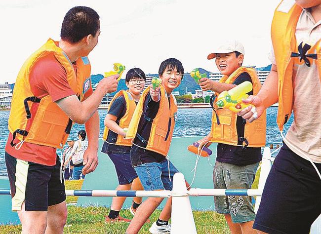 水鉄砲で相手の的をねらうミズサバの参加者＝松江市袖師町、岸公園