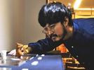個展に出品した根付を眺める永島信也さん＝東京都文京区、ギャラリー花影抄