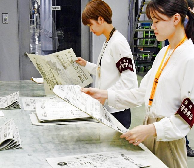 刷り上がった公報をチェックする島根県選挙管理委員会事務局の職員＝出雲市斐川町上庄原、山陰中央新報製作センター