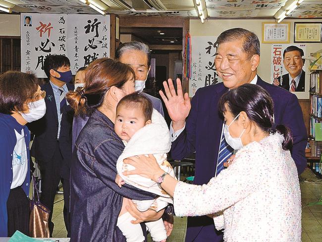 １２選を果たし、笑顔で支援者に手を振る石破茂氏（中央）＝３１日午後８時５９分、鳥取市戎町の事務所（久保田康之撮影）