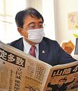 ６選を伝える新聞に目を通す赤沢亮正氏＝米子市加茂町１丁目、事務所