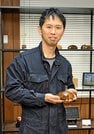 自作の一輪挿しを手にする木工家の村山創達さん＝松江市大庭町
