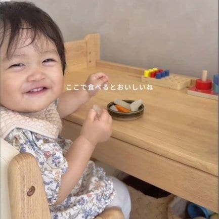 キッズデスクに座っておやつを食べるrinちゃん/Rinmama(@rin_mama0805)さん 提供