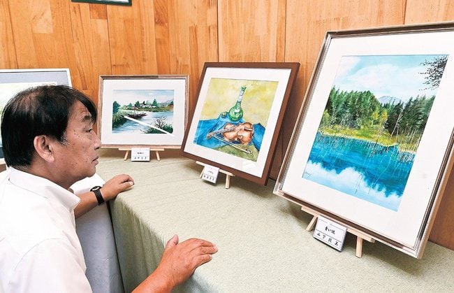 個性豊かな水彩画を楽しむ来場者＝松江市東出雲町揖屋、東出雲まちの駅女寅