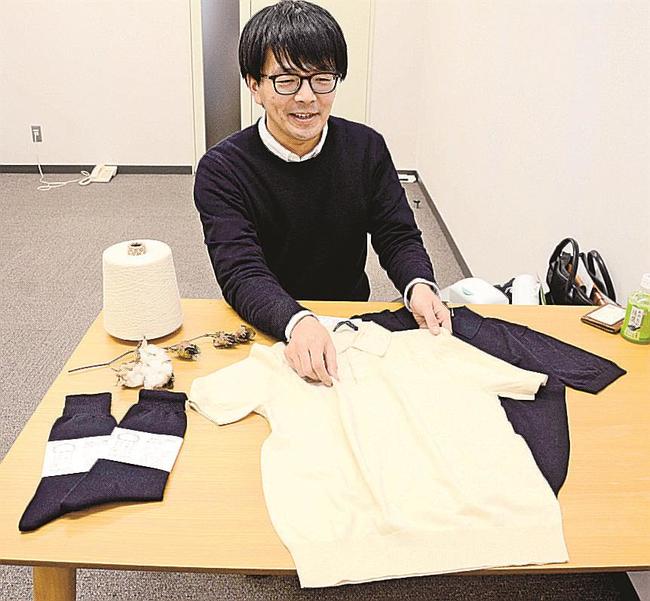自ら栽培したコットンを使ったポロシャツを手にする藤原潤さん＝松江市北陵町、テクノアークしまね