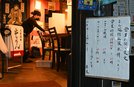 「まん延防止等重点措置」初日に、午後９時近くなり、店じまいする店員＝２７日午後８時５８分、松江市寺町の大衆酒場串かっちゃん