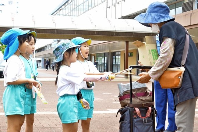 通行人に注意を呼びかけ広報物を配布する園児＝鳥取市東品治町、ＪＲ鳥取駅