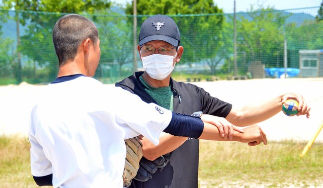 ボールのスピンの効かせ方を指導する大野豊さん＝出雲市大津町、出雲商業高校
