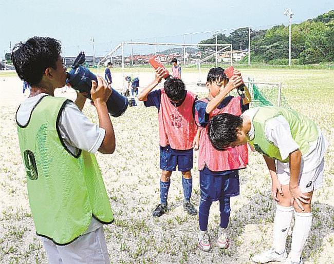 水分補給や体に水をかけるなどして熱中症対策を講じる中学生＝松江市内