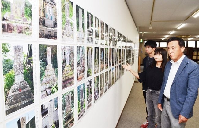 頌徳碑の写真を紹介する篠原隆事務局長（右）たち＝浜田市下府町、いわみ文化振興センター
