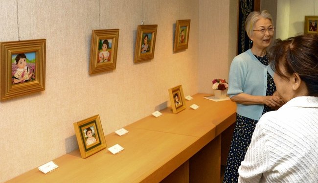 鮮やかなガラス絵を来場者に説明する丸山柚美さん（左）＝米子市角盤町１丁目、ＪＵ米子高島屋