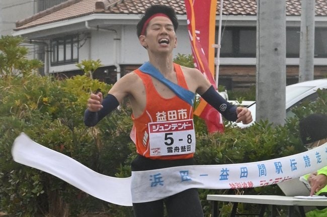 優勝のゴールテープを切る雪舟益田の大庭一心=浜田市市原井町、浜田お魚市場前