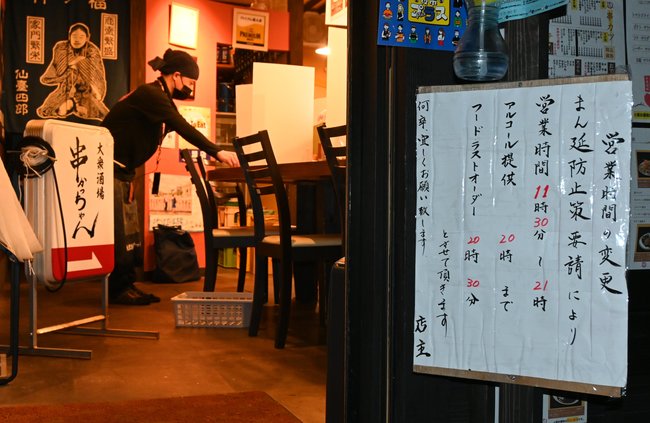 「まん延防止等重点措置」初日に、午後９時近くなり、店じまいする店員＝２７日午後８時５８分、松江市寺町の大衆酒場串かっちゃん