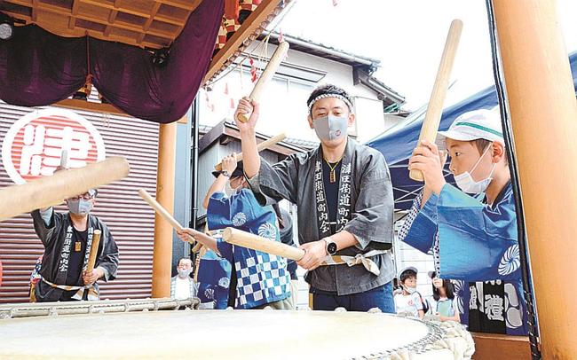 雑賀津田街道のメンバーに鼕のたたき方を教わる児童＝松江市雑賀町