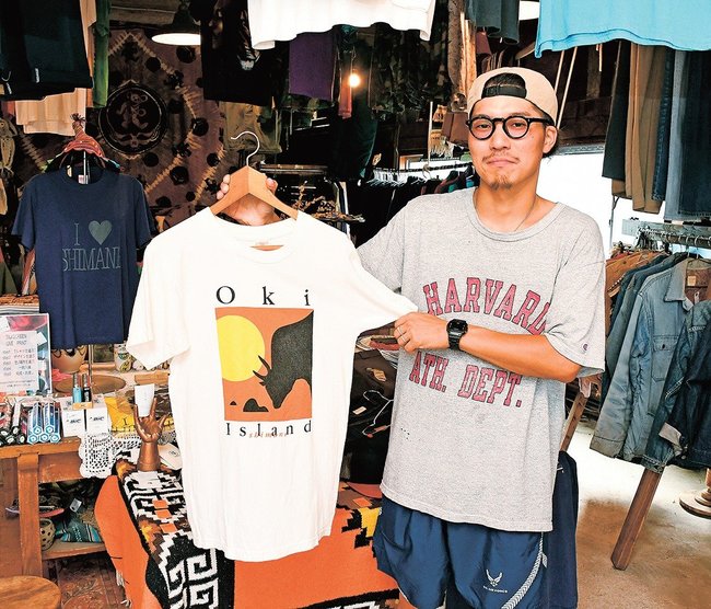 南アジアで見つかり、隠岐に来たＴシャツを展示する加藤翔さん＝島根県隠岐の島町南方、エルブスクロージングストア