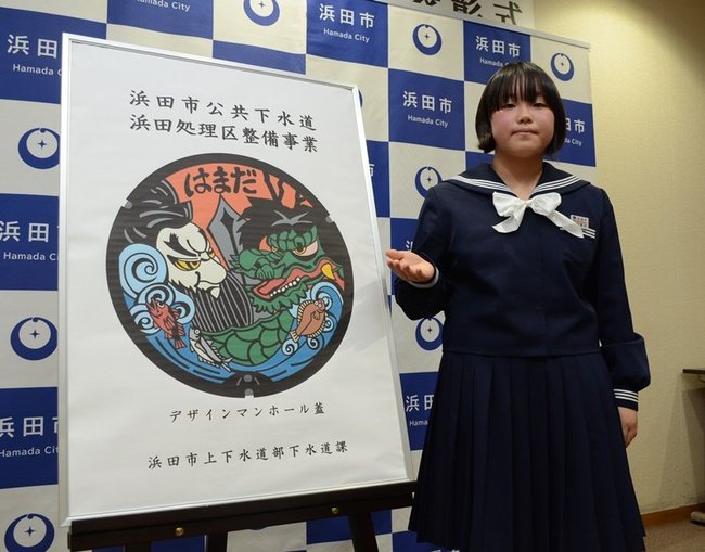 最優秀賞に輝いたマンホールぶたのデザインを紹介する岡田早代さん＝浜田市殿町、市役所