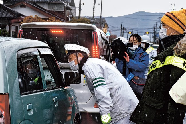 運転者に交通事故の防止を呼びかける参加者＝境港市誠道町、県道米子空港境港停車場線
