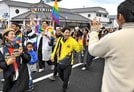 パレードの参加者とともに沿道に手を振る佐藤みどりさん（中央、黄色のジャケットを着用）＝松江市殿町