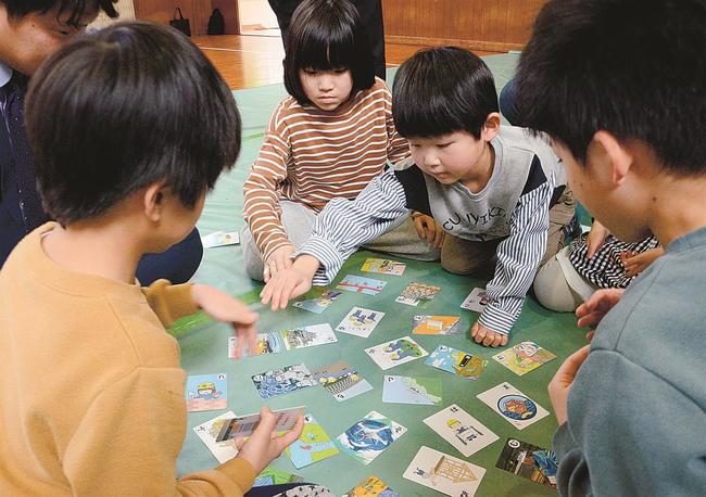 建設業にまつわるかるたの絵札を取る子ども＝松江市古志原５丁目、双樹学院