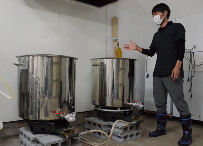 醸造に使う器具を紹介する石田章さん（44）＝出雲市多伎町久村、出雲多伎ブルワリー