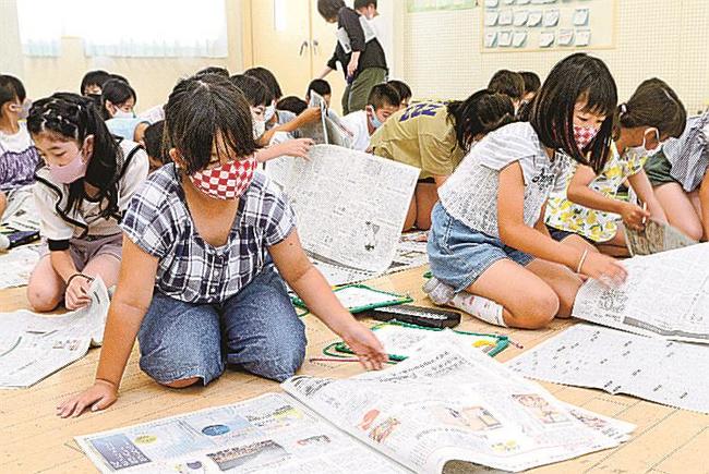 新聞をめくってクイズの答えを探す児童＝松江市東津田町、津田小学校