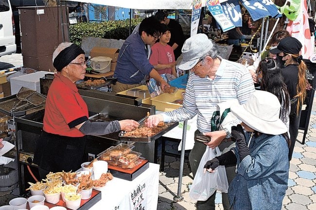 白イカのゲソやハタハタの骨の揚げ物などを買い求める来場者（右）＝境港市、海岸通り