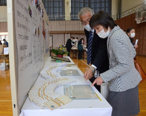 アコさんから届いた封筒や手紙に見入る来場者＝島根県奥出雲町三成、町民体育館