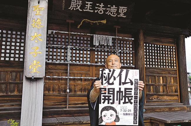 50年ぶりとなる聖徳太子像の公開をPRする住職の内田広平さん。後方の聖徳太子堂に像が安置されている=松江市竪町、信楽寺