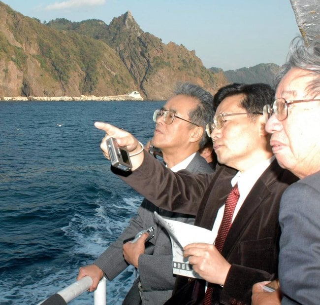 遊覧船から鬱陵島の地形を確認する下條正男座長(右から2人目)ら竹島問題研究会のメンバー=2006年11月、韓国・鬱陵島沖