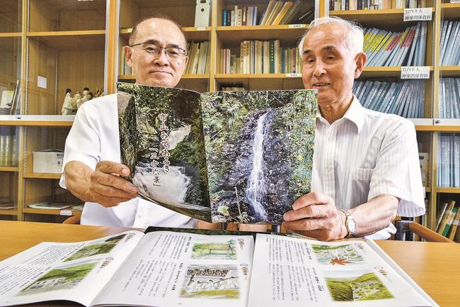 発刊した「市山みてあるき『三十六景』」の仕上がりに目を通す市山郷土研究会の田中直文会長（右）ら＝江津市桜江町市山、市山地域コミュニティ交流センター